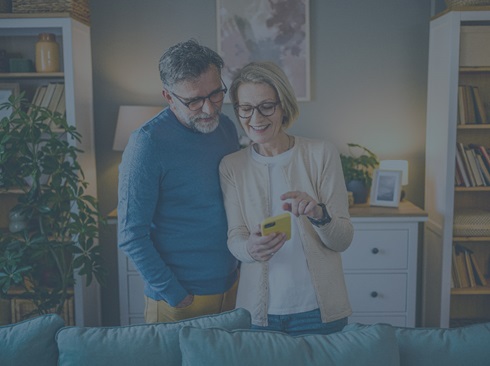 Two people in a home looking at a phone